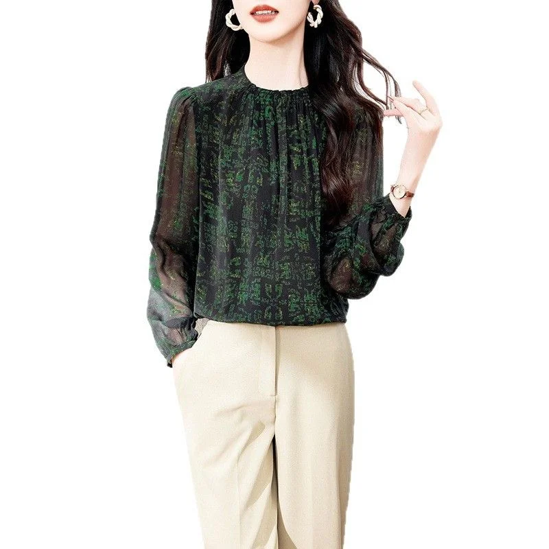 Crepe Silk Print Shirt — A green printed crepe de chine silk shirt with a gathered neck and sheer long sleeves, worn with cream trousers